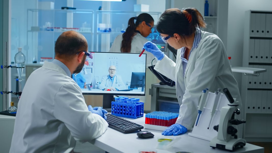 Lab technicians talking on video call with professional chemist doctor